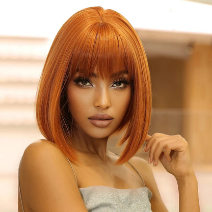 Woman with orange hair and a silver top against a blurred background